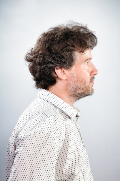 卷曲的头发，胡子成熟的真正的男人的侧面图片下载