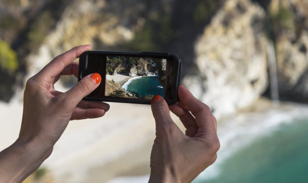 游客用手机给麦克威瀑布拍照图片下载