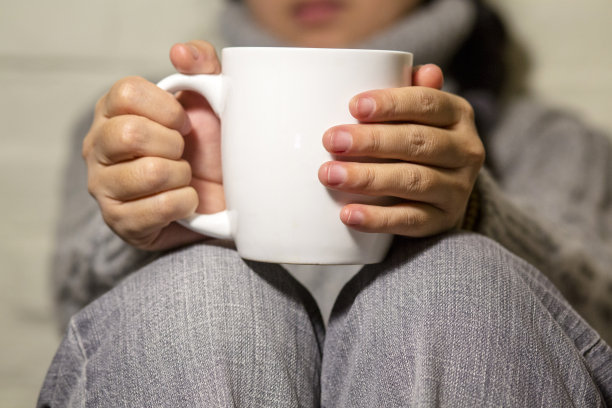 晚上拿着杯子在沙发上喝酒的女孩图片下载