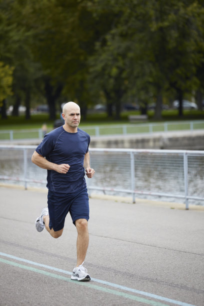 运动员海军健身运动服在公园里跑步图片下载