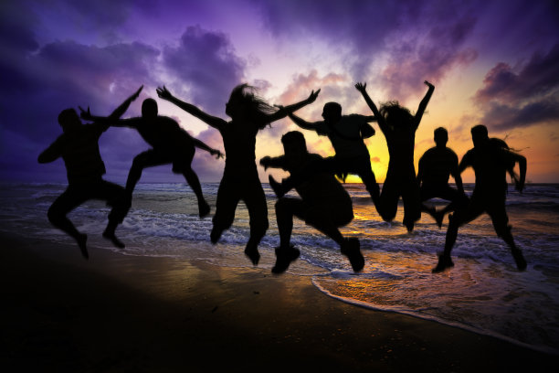 春假期间，一群年轻人在沙滩上蹦蹦跳跳图片下载