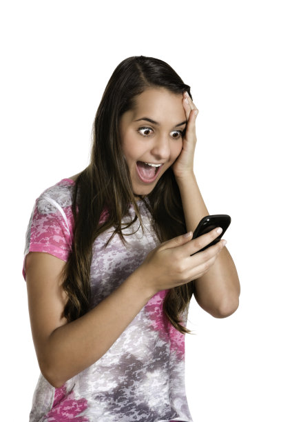 惊讶的西班牙裔年轻女子在读手机图片下载