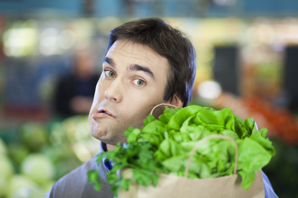 年轻人拿着杂货袋，做出疯狂的表情。图片下载