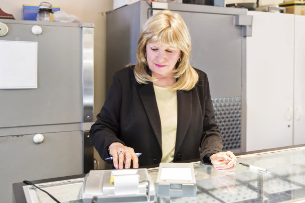 女性白人珠宝店老板在销售期间使用计算器图片下载