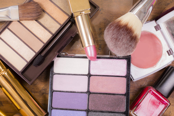 成堆的各种化妆品、化妆品躺在木制的梳妆台上。图片下载