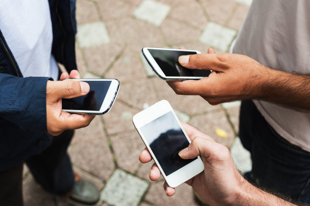 三个朋友在公园里用平板电脑和智能手机图片下载