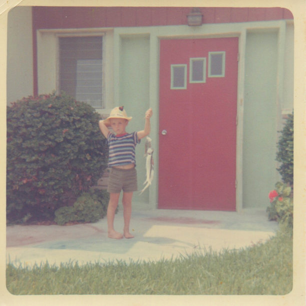 一个男孩拿着一串鱼的照片图片下载