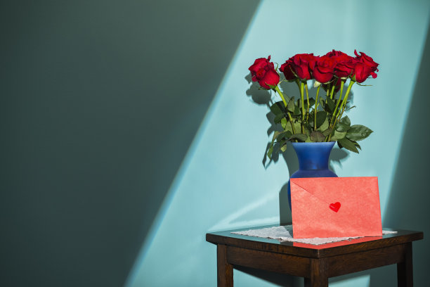 窗外的灯光照在一打红玫瑰和卡片上图片下载