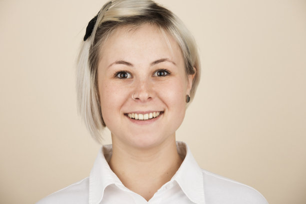 在光线背景下，年轻女子在工作室摆姿势的大头照图片下载