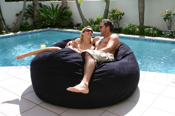 一对年轻夫妇在泳池边放松图片下载