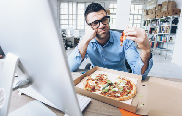 一个年轻人在工作时不愉快的午休时间图片下载