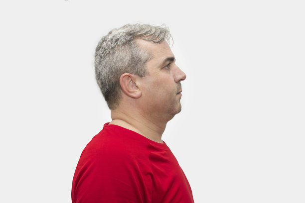 灰色背景下严肃的中年男子的侧面视图图片下载