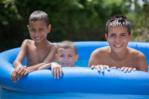 三个十几岁的男孩在游泳池里享受图片下载