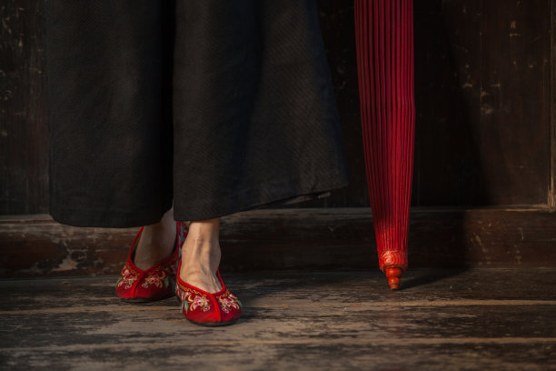 女人的脚在红色的鞋与伞的特写图片下载