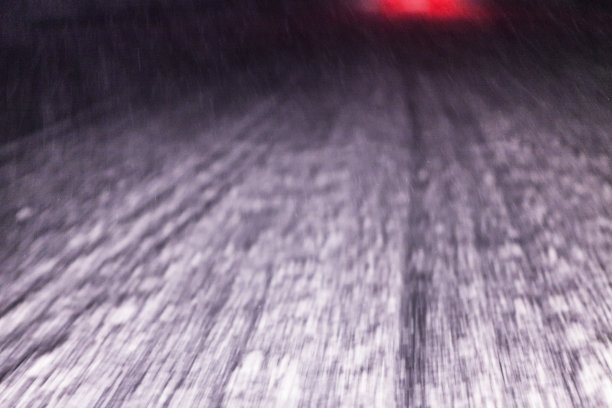 高速行驶的汽车正接近暴风雪雪高速公路，尾灯闪烁图片下载