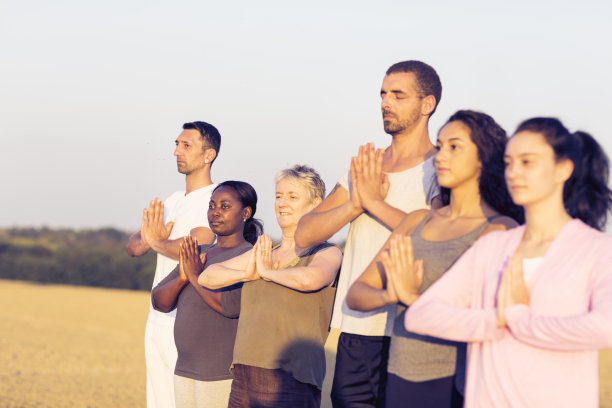 日落时分在户外集体练习瑜伽图片下载