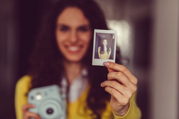 年轻女孩展示即时的自画像图片下载