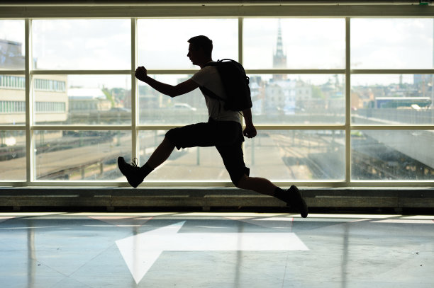 男人在剪影中奔跑，窗户，背景是斯德哥尔摩图片下载