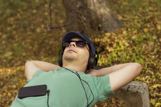 微笑随意的家伙在手机上听音乐图片下载