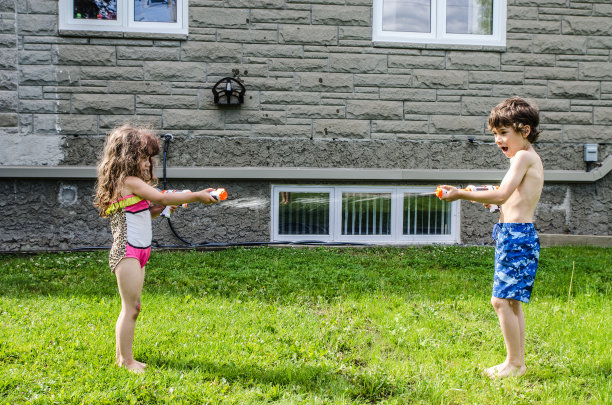 男孩和女孩用水枪射水图片下载