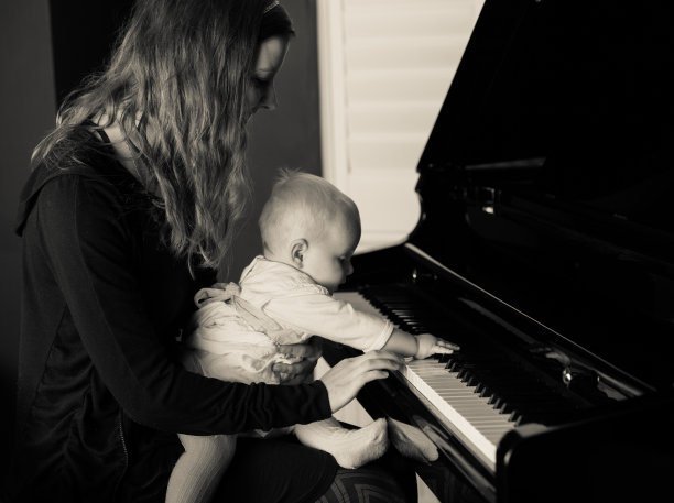 抱着孩子弹钢琴的女人图片下载