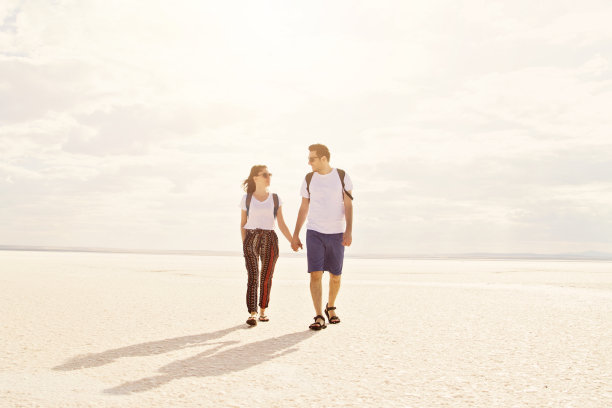 一对幸福的情侣在夕阳下走在雪地上图片下载