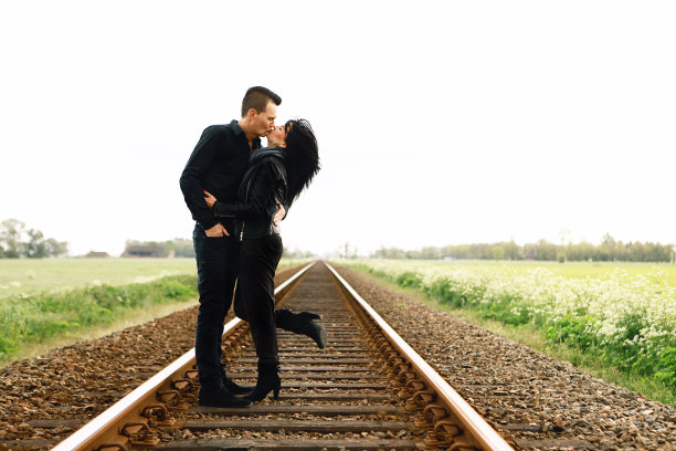 男人在铁轨上亲吻妻子图片下载
