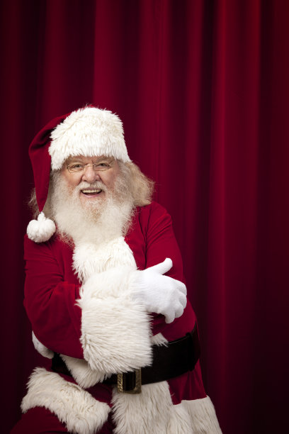 红色窗帘下的真正圣诞老人的照片图片下载