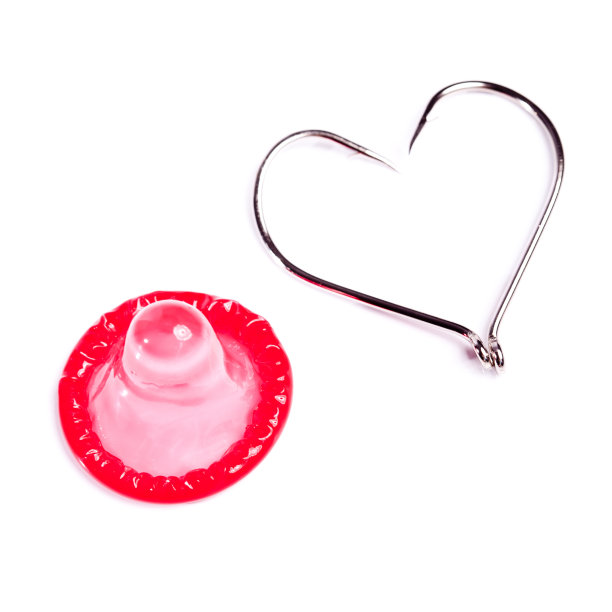 红色的避孕套和挂钩，形成心形图片下载