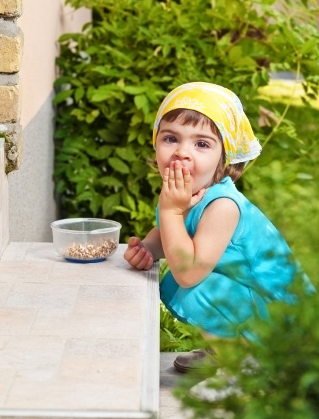 可爱的小女孩在户外吃零食肖像图片下载