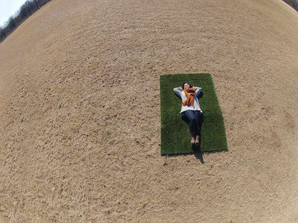 年轻女子在一片绿草地上图片下载