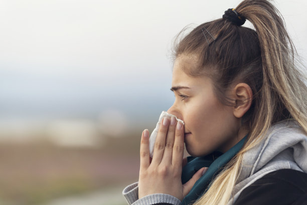 患有流感或过敏的妇女在外面打喷嚏图片下载