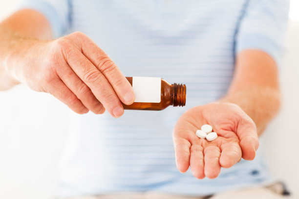 男人的手从瓶子里取出药丸图片下载