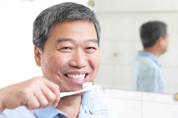 微笑的老人在镜子旁边刷牙图片下载