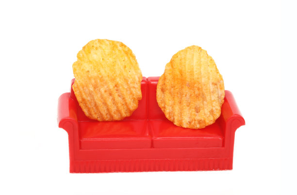 白色背景下的红色沙发上的薯片图片下载