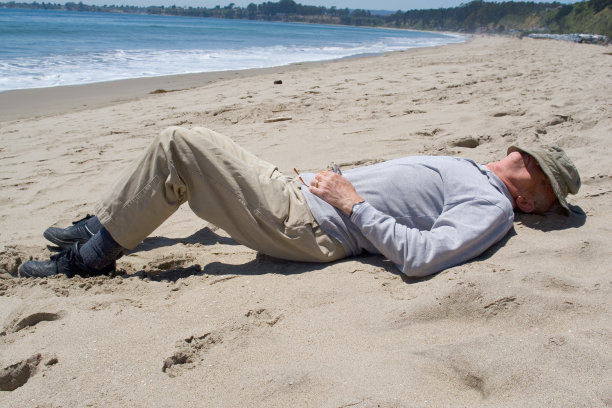 在海滩上睡着的老人图片下载