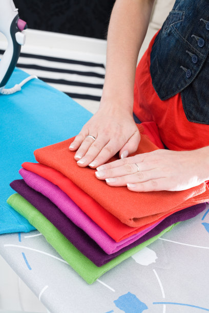 折叠衣服上的女性手图片下载