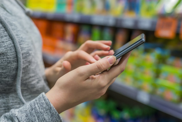 女人在手机上查看购物清单素材图片