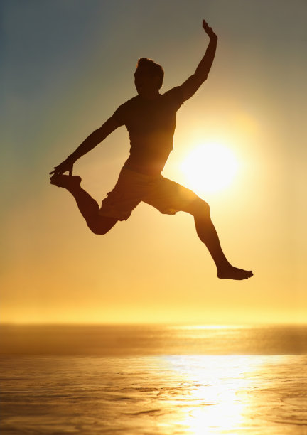 夕阳下一个人在半空中跳跃的剪影图片下载