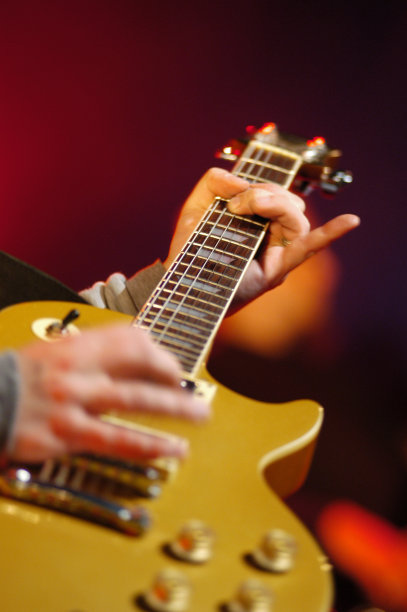 一个音乐家在红色上弹奏吉他的特写图片下载
