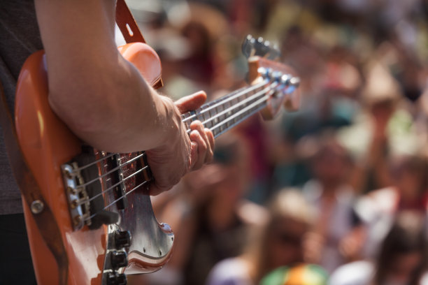 户外表演时，贝斯手在人群前演奏图片下载