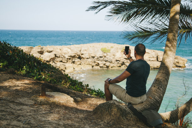 一个男人在海滩上拍照图片下载
