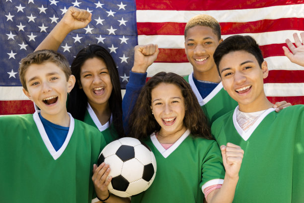运动:青少年朋友足球队与美国国旗背景。图片下载