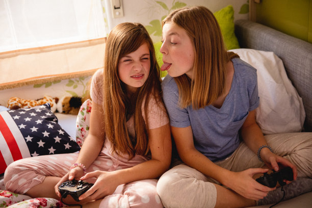 女孩在卧室玩电脑游戏时做鬼脸图片下载