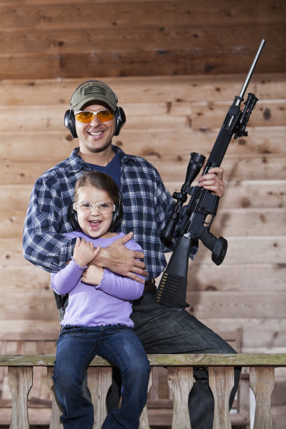 女孩和父亲拿着步枪。图片下载
