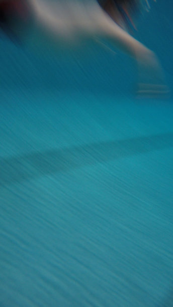 一个男孩在游泳池里游泳图片下载