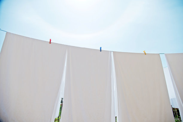 白色床单和毛巾挂在晾衣绳上图片下载