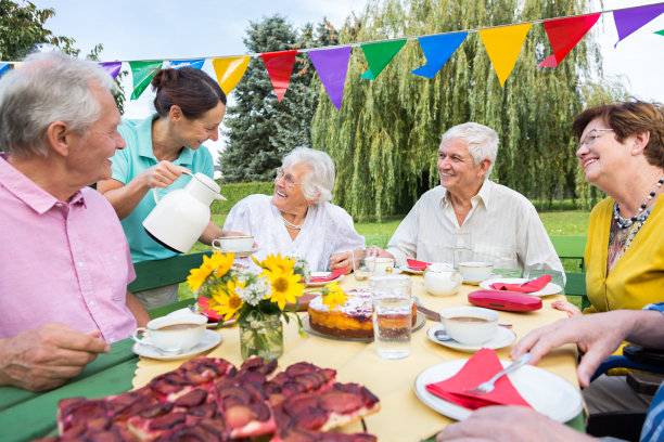 一群老人坐在花园的桌子旁图片下载