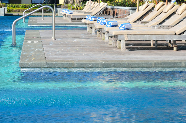 日光浴床旁边的热带度假村游泳池图片下载