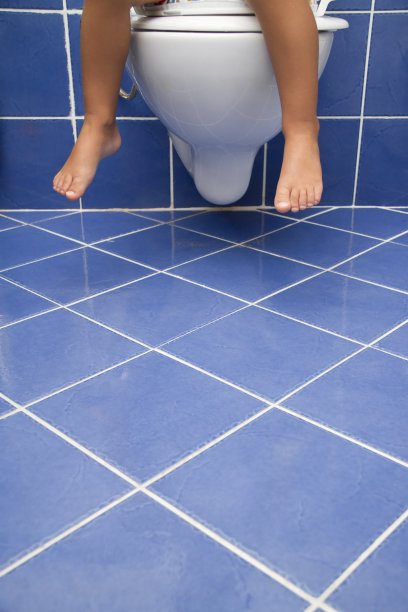 孩子坐在浴室里的马桶上图片下载